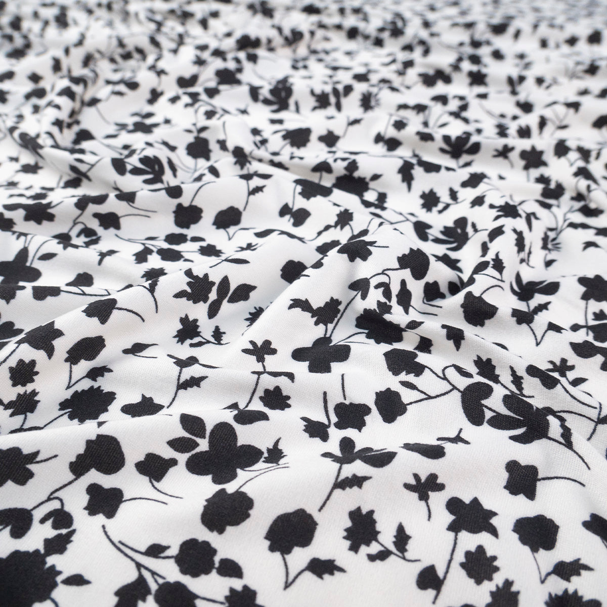 PIEL DE DURAZNO ESTAMPADO BLANCO BRILLANTE FLORES NEGRAS
